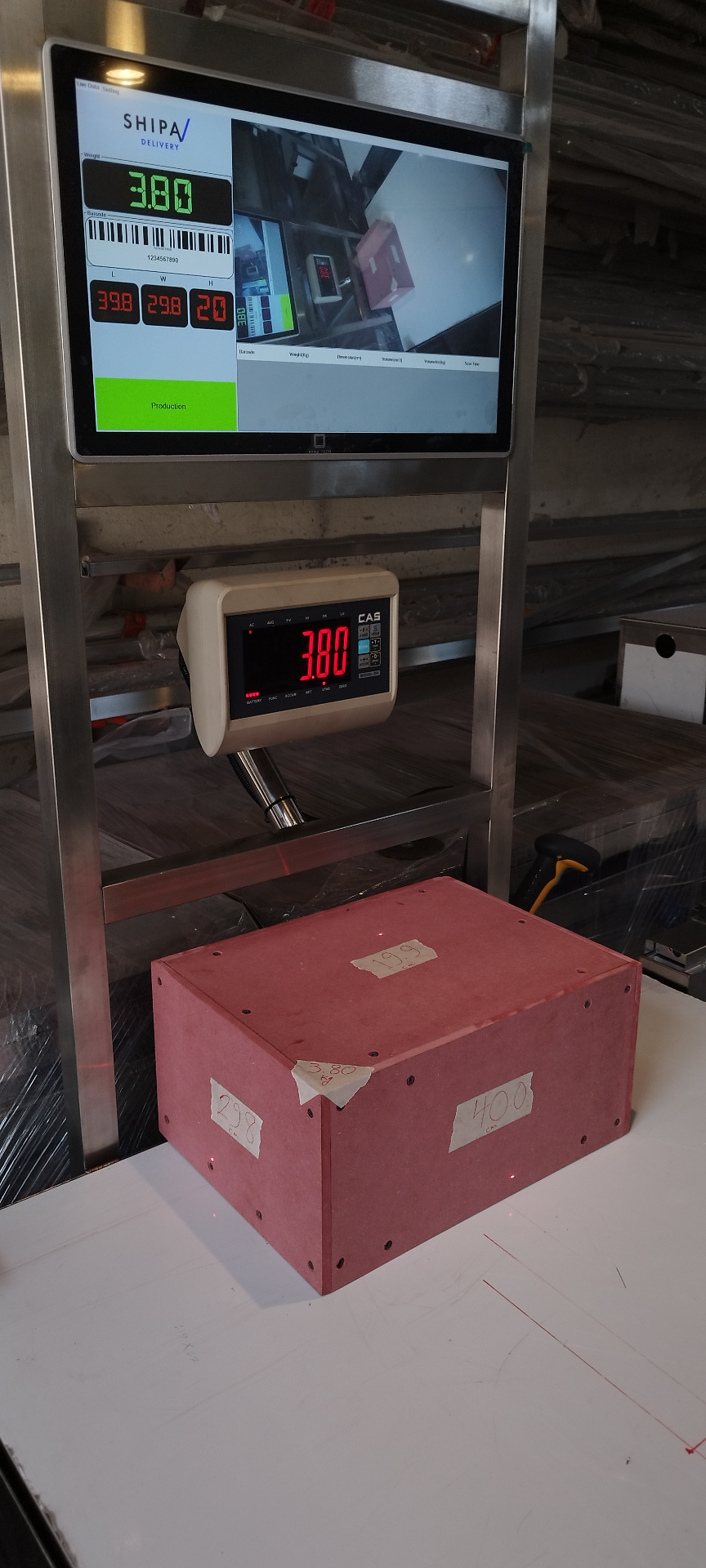Hybrid DWS measuring a calibration parcel — printed dimensions on the box match the values on the machine screen